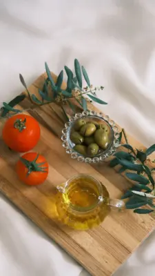 Aceitunas, tomates y aceite de oliva sobre una tabla de madera
