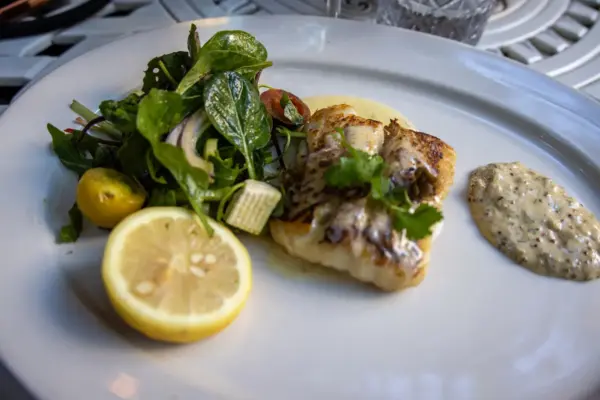 Pescado a la plancha con ensalada servido en un plato