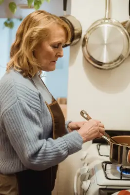 Mujer removiendo los ingredientes de un guiso en la cocina
